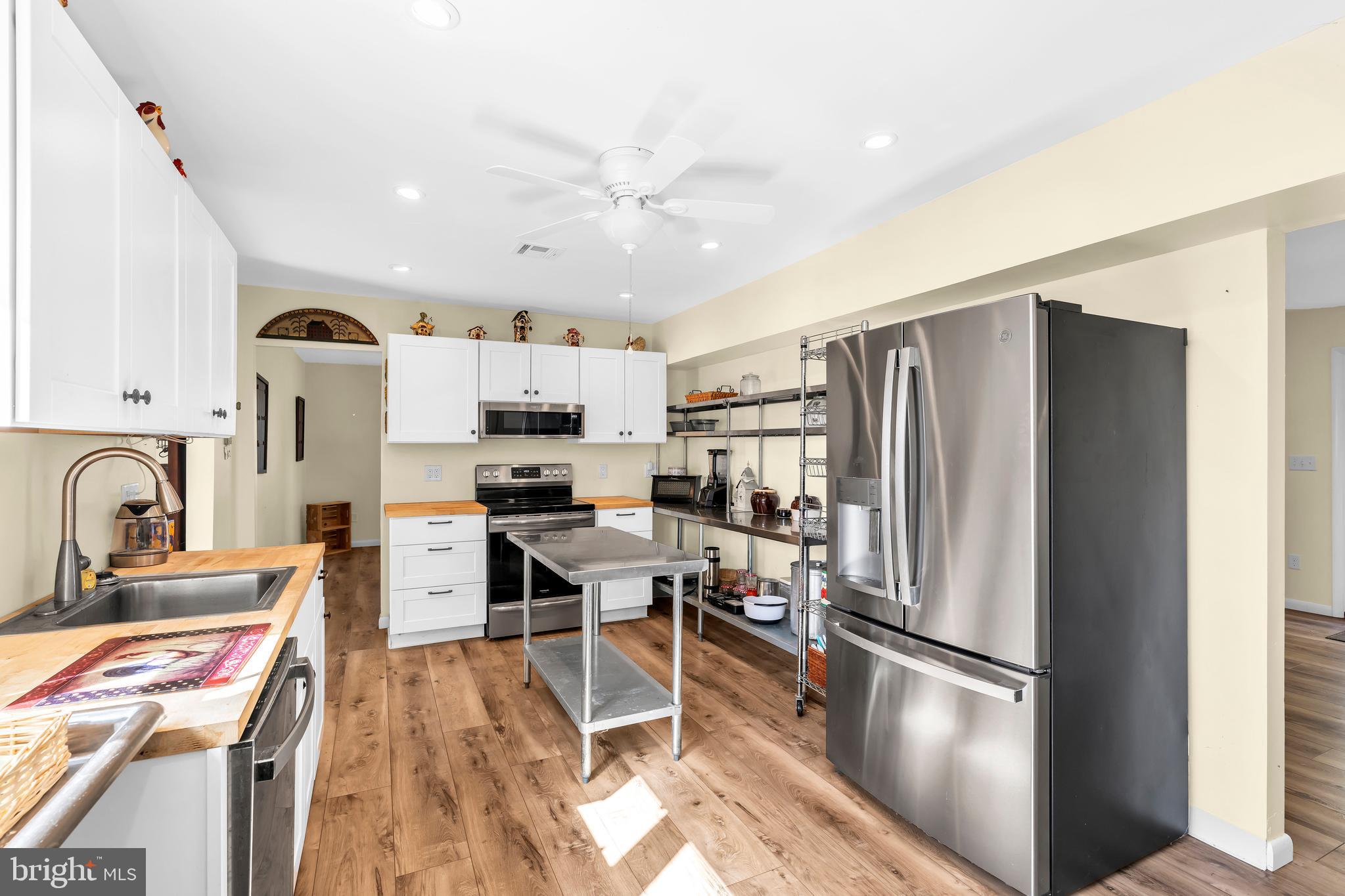 70 MacKenzie Road Hampton, NJ 08827 - Photo 30 of 45 a kitchen with stainless steel appliances a refrigerator a stove a sink dishwasher and white cabinets with wooden floor