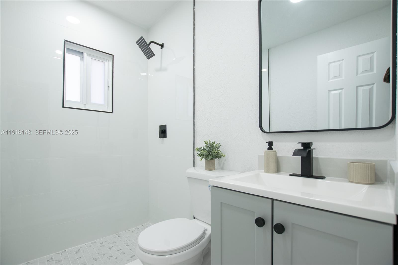 2250 Northwest 95th Terrace Miami, FL 33147 - Photo 13 of 18 a bathroom with a toilet sink and mirror