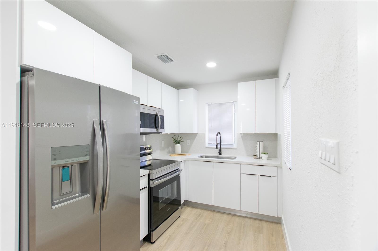 2250 Northwest 95th Terrace Miami, FL 33147 - Photo 7 of 18 a kitchen with a sink stainless steel appliances and cabinets
