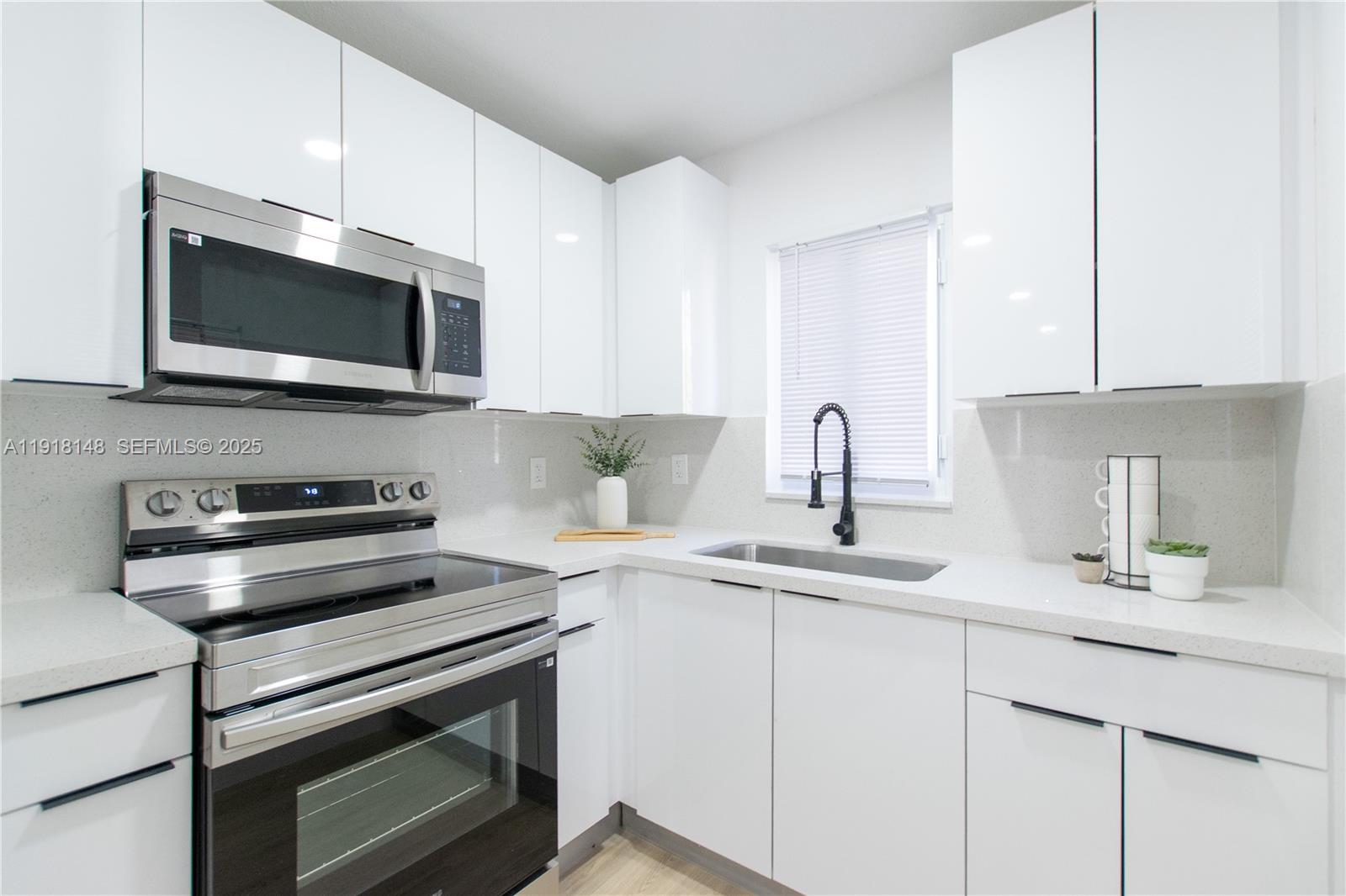2250 Northwest 95th Terrace Miami, FL 33147 - Photo 8 of 18 a kitchen with stainless steel appliances a stove microwave and sink