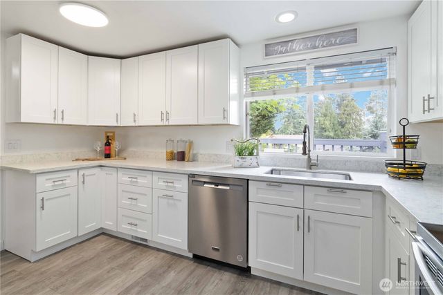 a kitchen with white cabinets white appliances and sink