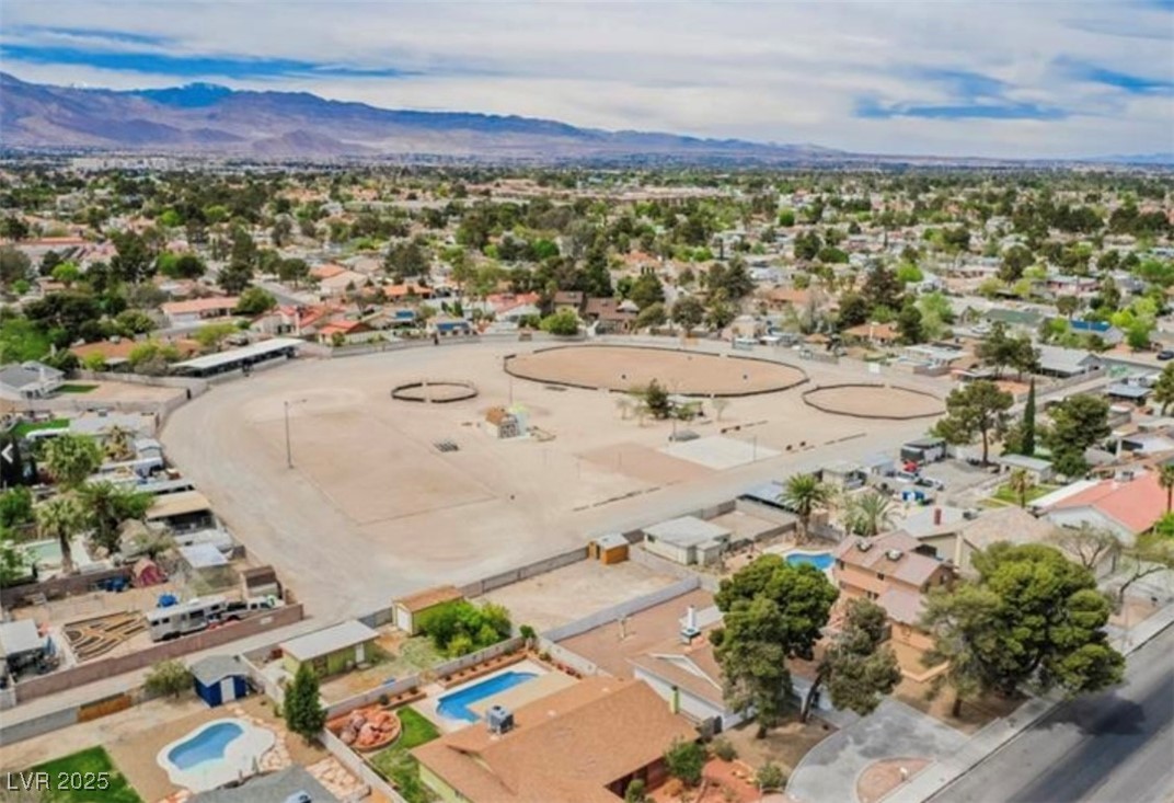 Aerial perspective of suburban area with a mountain backdrop and a pool area