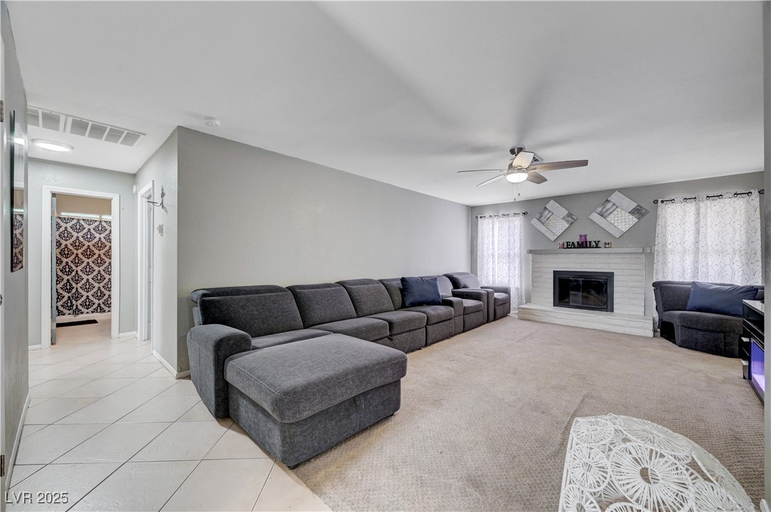 2829 Michael Way Las Vegas, NV 89108 - Photo 16 of 60 Living area featuring a fireplace, light tile patterned floors, and a ceiling fan