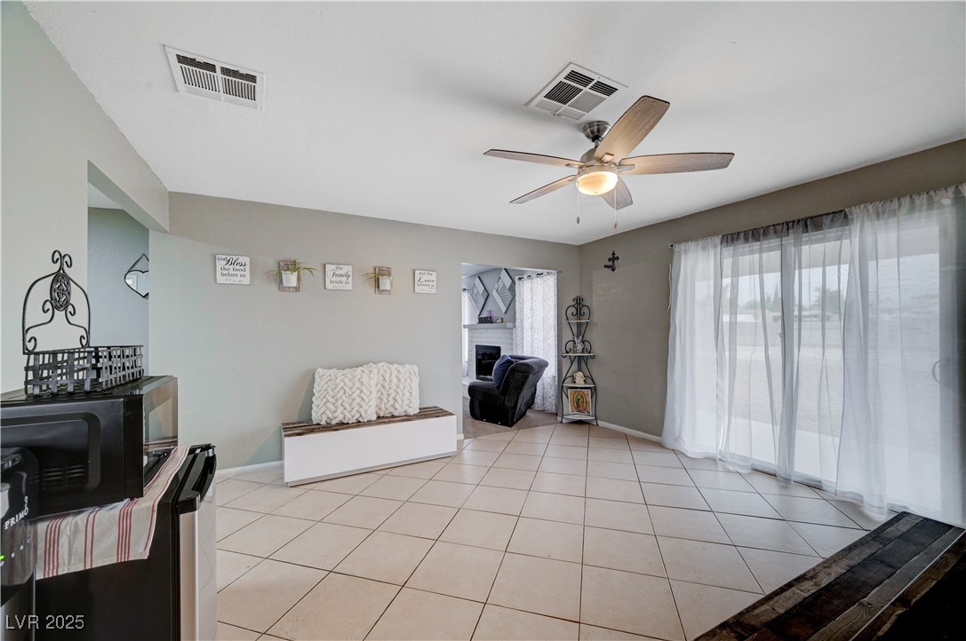 2829 Michael Way Las Vegas, NV 89108 - Photo 27 of 60 Living area featuring light tile patterned floors, a fireplace, and a ceiling fan