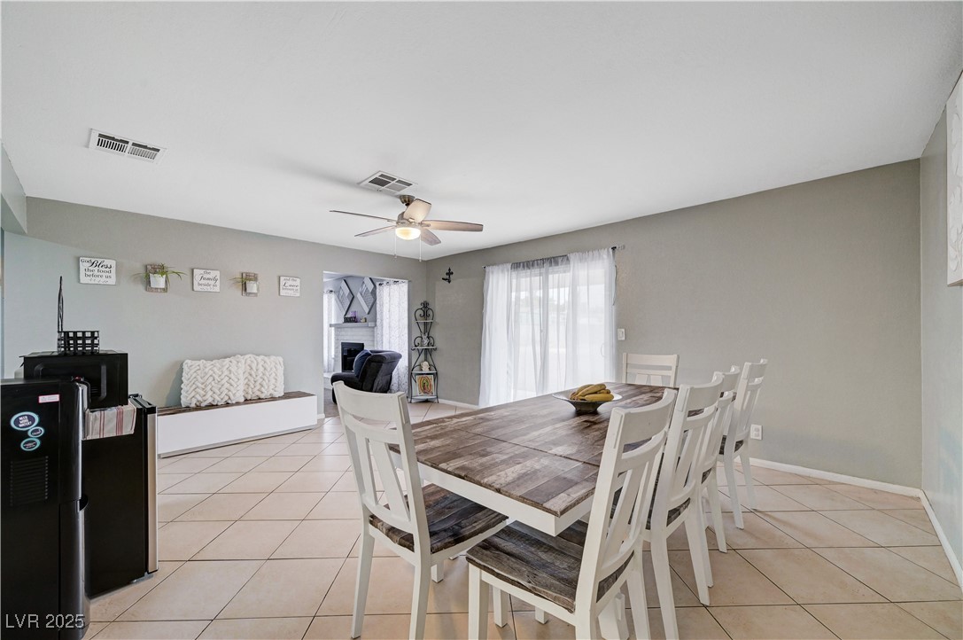 2829 Michael Way Las Vegas, NV 89108 - Photo 28 of 60 Dining room with light tile patterned floors, a fireplace, and ceiling fan