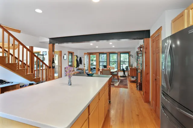 a dining hall with stainless steel appliances granite countertop a refrigerator and a view of living room