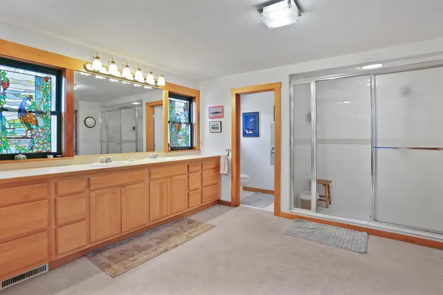 a spacious bathroom with a double vanity sink and a mirror