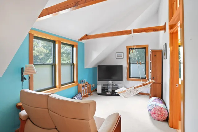 a living room with furniture a flat screen tv and a floor to ceiling window
