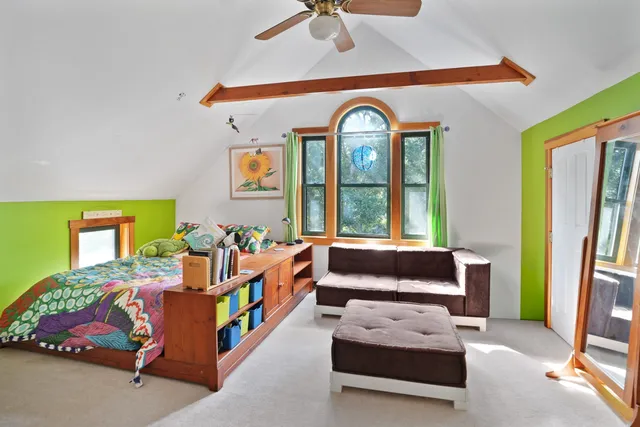 a bedroom with furniture and a large window