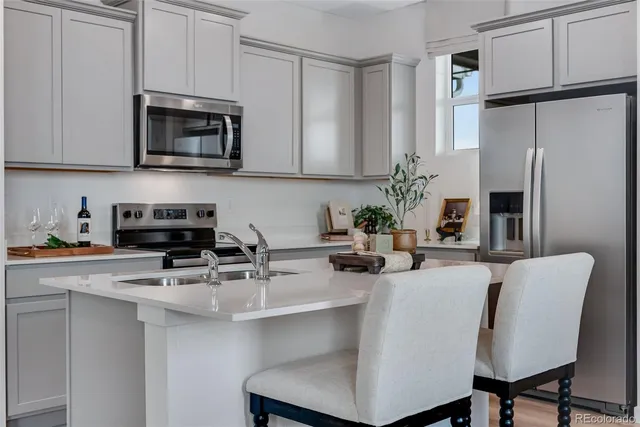 a kitchen with stainless steel appliances a stove refrigerator sink and cabinets