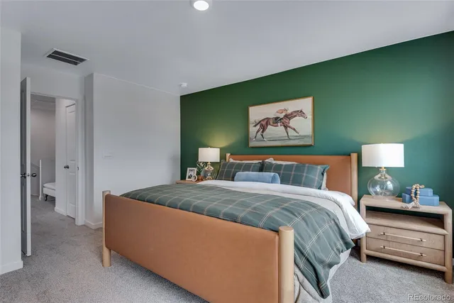 a bedroom with a bed and a painting on the wall