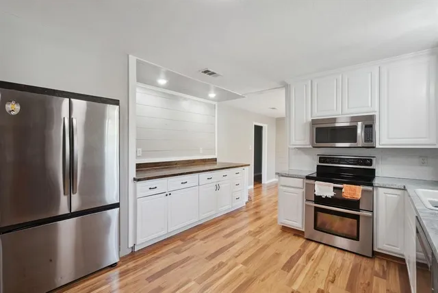 a kitchen with stainless steel appliances a refrigerator and a stove top oven