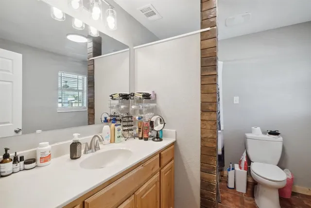 a bathroom with a sink a toilet and shower curtain