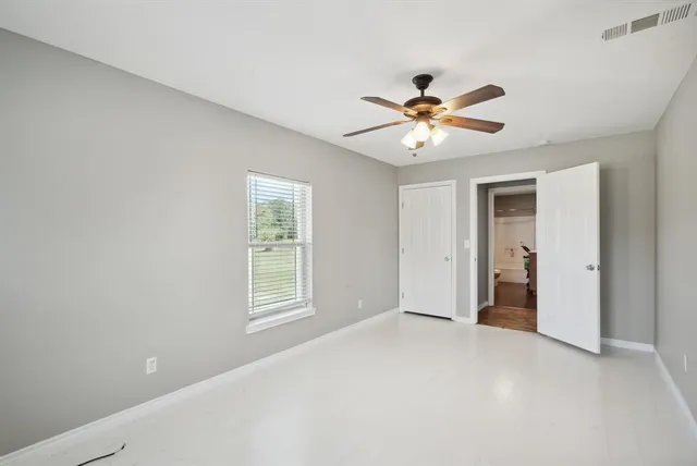 a view of a room with a ceiling fan and a window