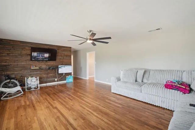 a living room with furniture and a wooden floor