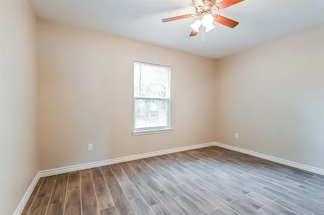 wooden floor in an empty room with a window