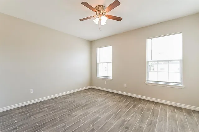 wooden floor in an empty room with a window
