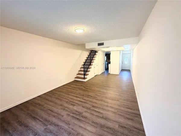 a view of an empty room with wooden floor