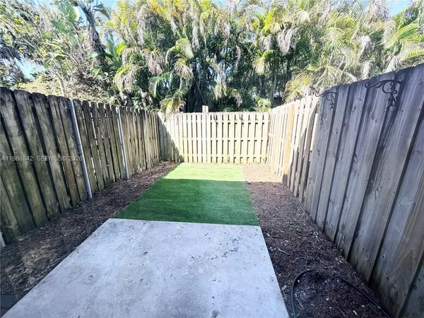 a view of a yard with wooden fence