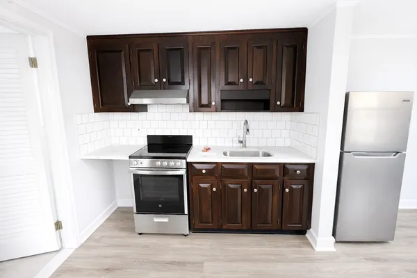 a kitchen with stainless steel appliances granite countertop a refrigerator and a stove top oven