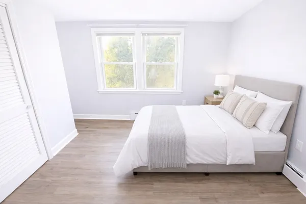a large bed sitting in a bedroom next to a window