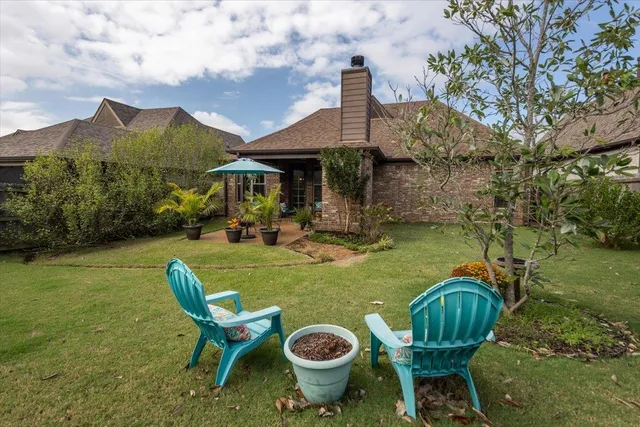 a view of a patio with table and chairs potted plants with wooden floor and fence