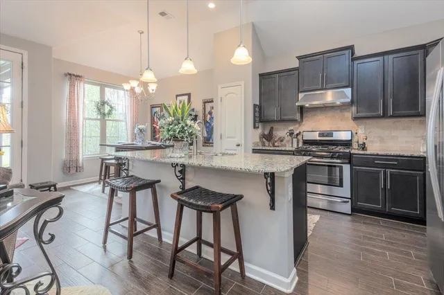 a view of a dining room with furniture a chandelier and wooden floor