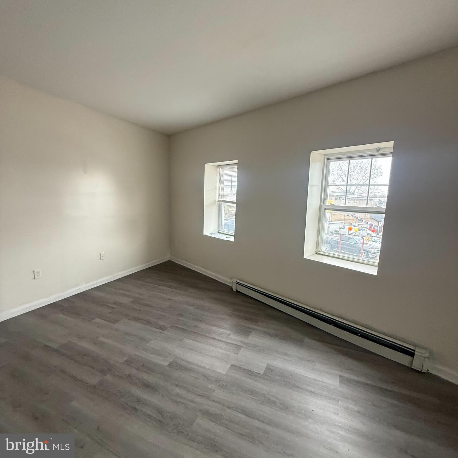 6805-07 Marshall Road Upper Darby, PA 19082 - Photo 9 of 11 an empty room with wooden floor and windows