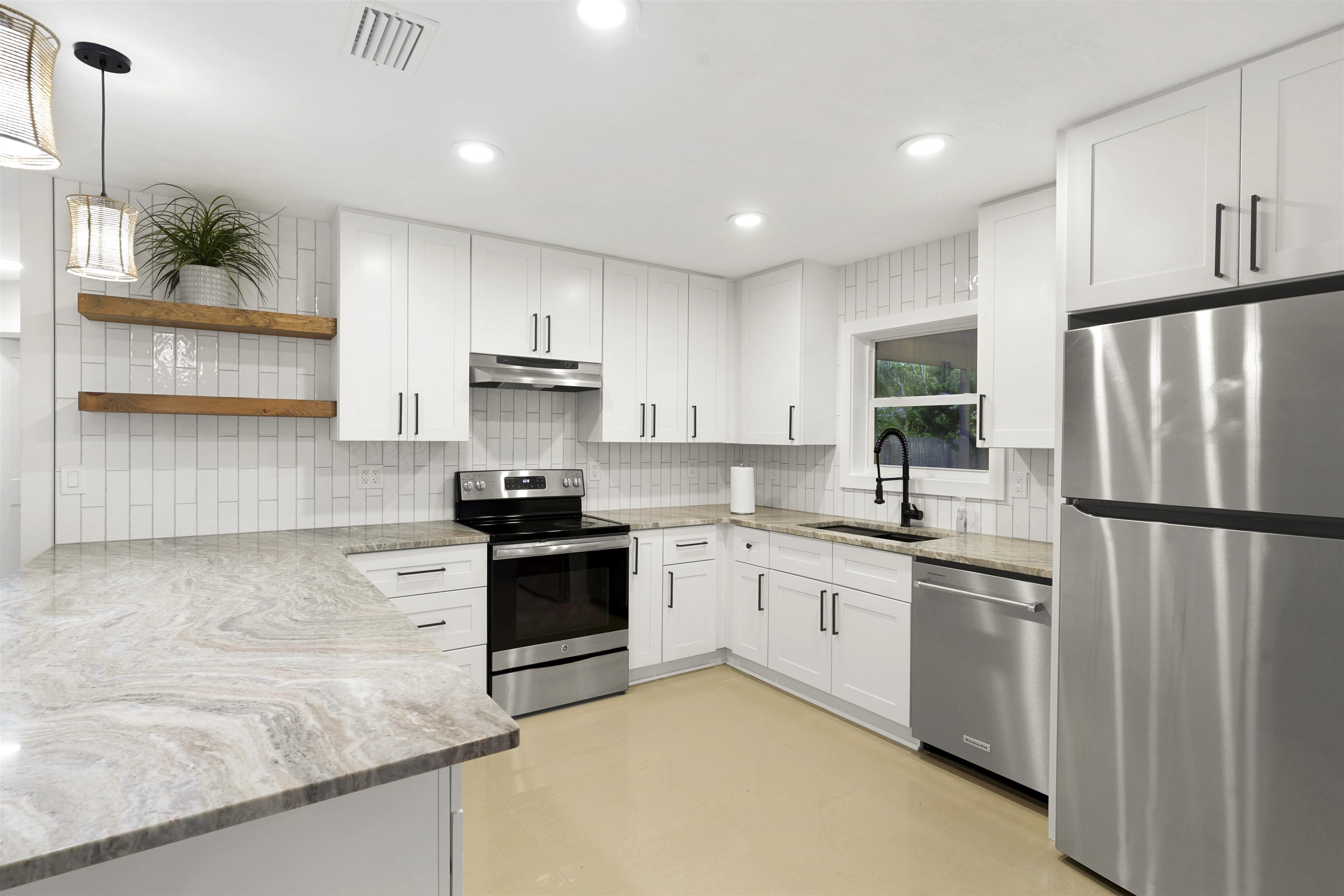 212 F Street St. Augustine, FL 32080 - Photo 11 of 35 a kitchen with white cabinets stainless steel appliances and a refrigerator