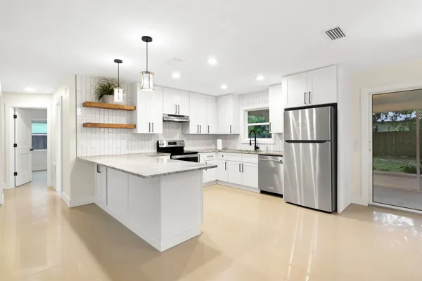 a kitchen with white cabinets and stainless steel appliances
