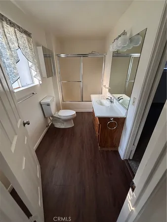 a view of a livingroom with furniture wooden floor and a kitchen
