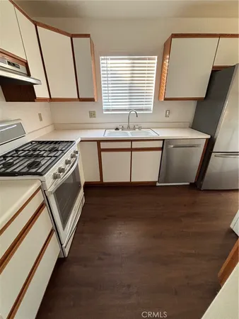 a kitchen with a sink a stove and cabinets