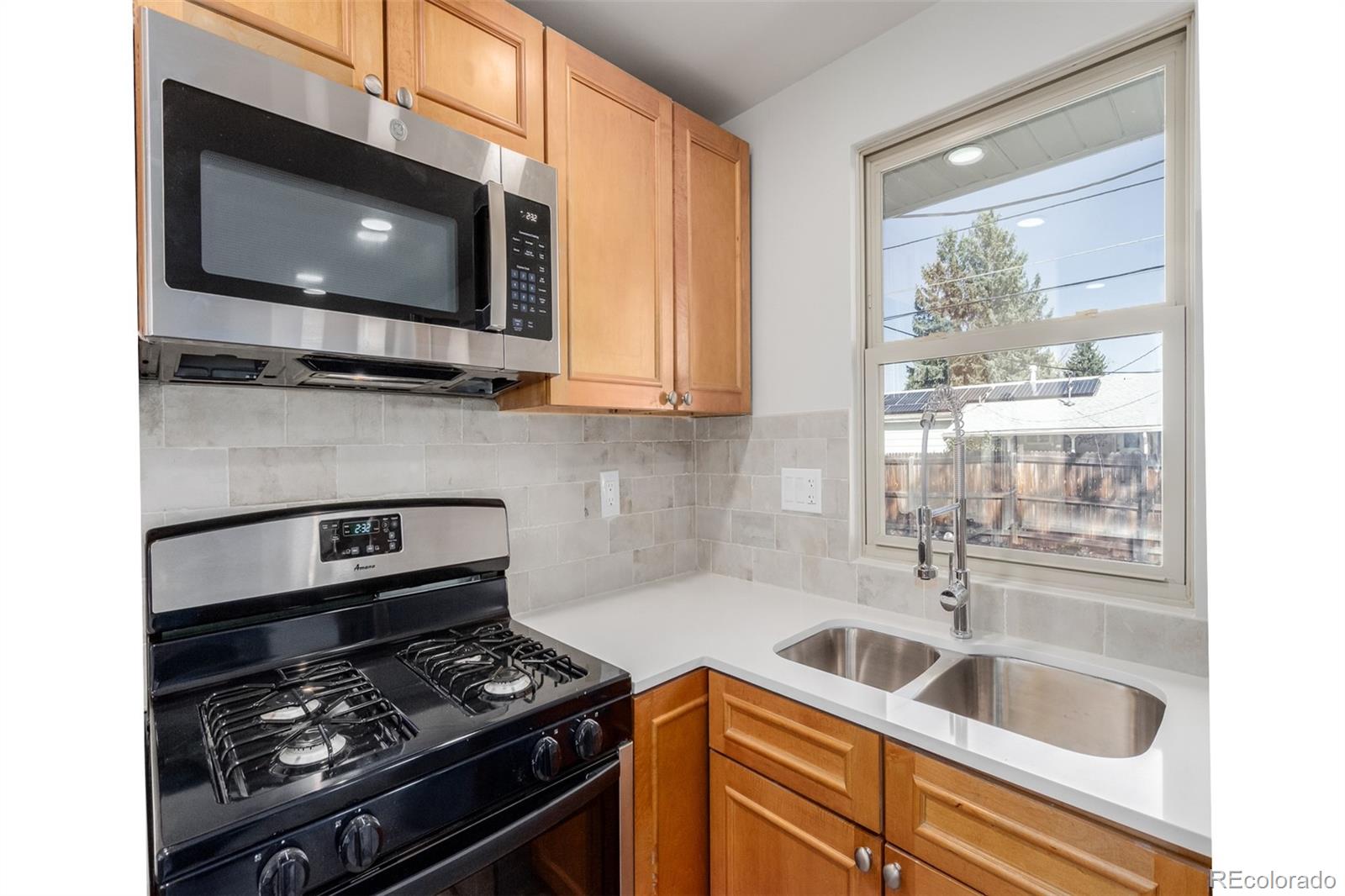 7330 Decatur Street Westminster, CO 80030 - Photo 13 of 37 a kitchen with stainless steel appliances a stove a microwave and sink