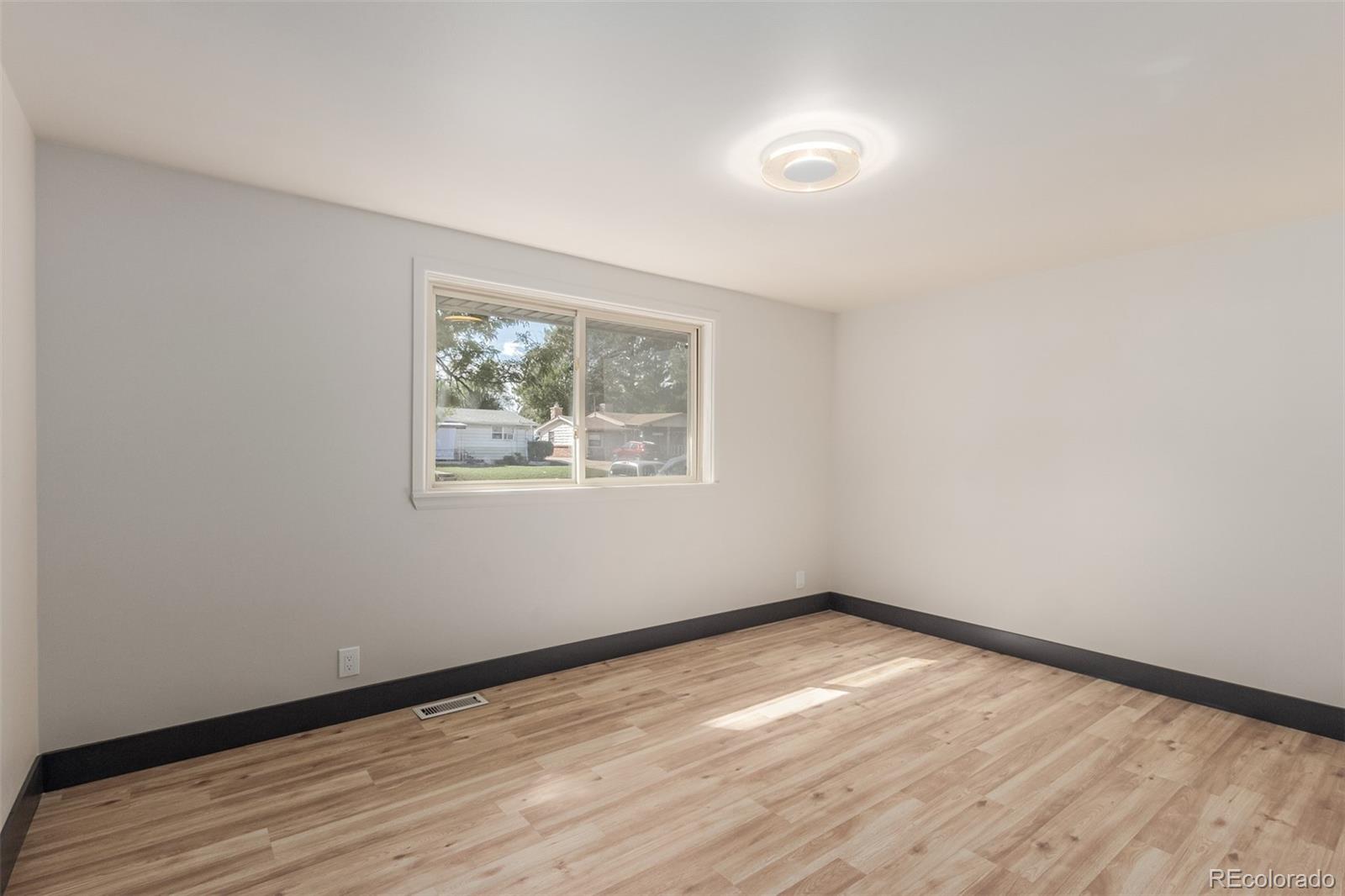 7330 Decatur Street Westminster, CO 80030 - Photo 14 of 37 an empty room with wooden floor and windows
