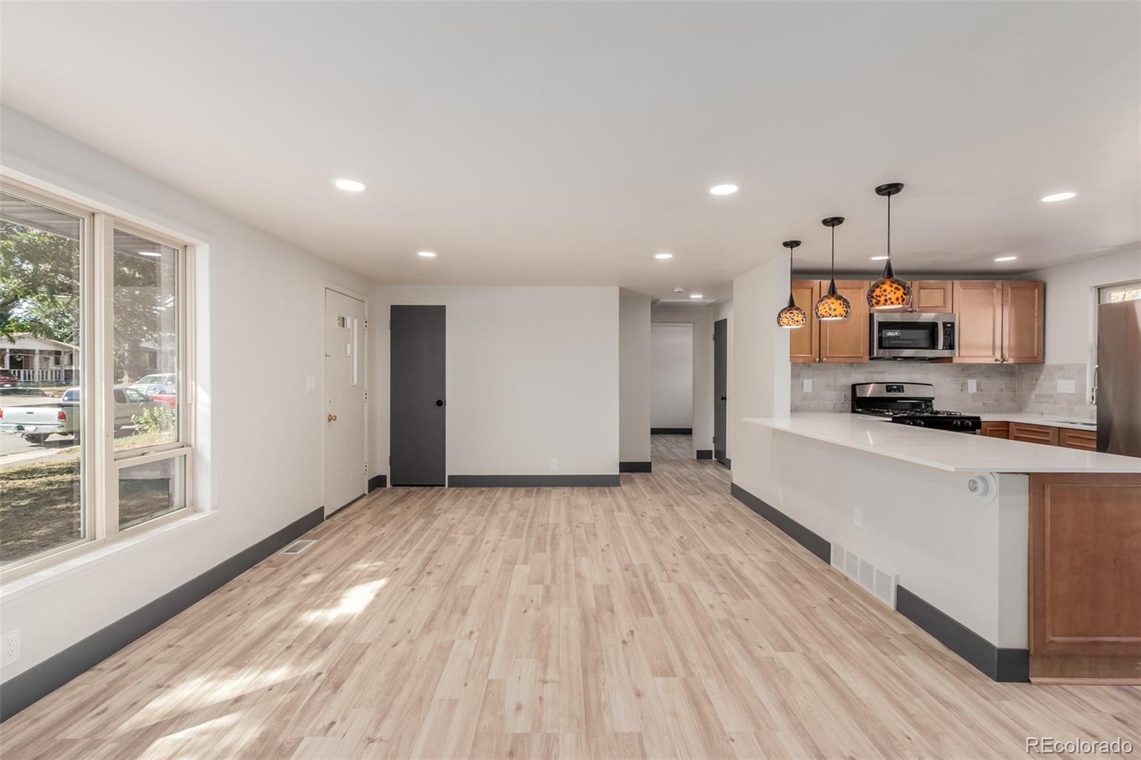 7330 Decatur Street Westminster, CO 80030 - Photo 9 of 37 a large kitchen with stainless steel appliances a large counter top a stove and a refrigerator