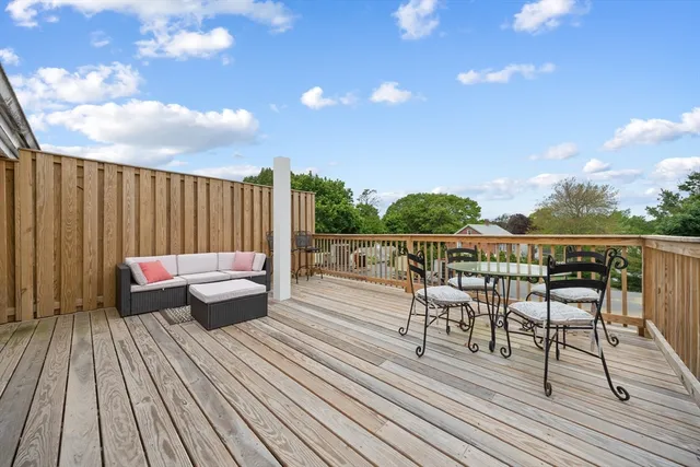 a roof deck with table and chairs