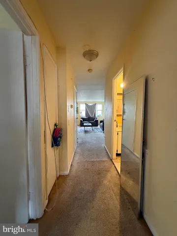 a view of a hallway with wooden floor and a living room