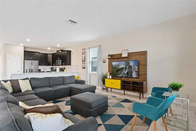 a living room with furniture and kitchen view