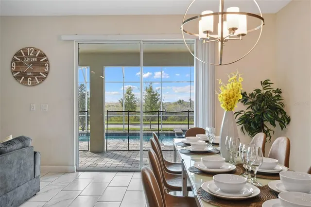 a dining room with furniture and a floor to ceiling window