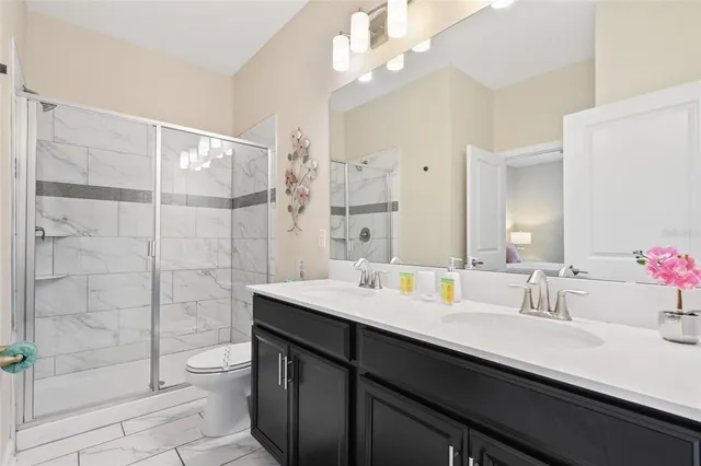 a bathroom with a double vanity sink mirror and shower