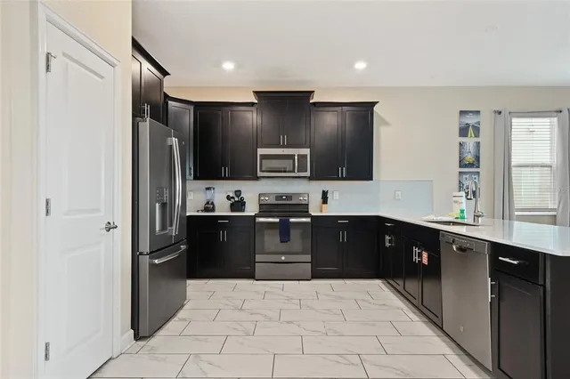 a kitchen with stainless steel appliances granite countertop a refrigerator and a sink