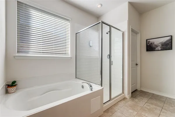 a bathroom with a tub a toilet and a shower