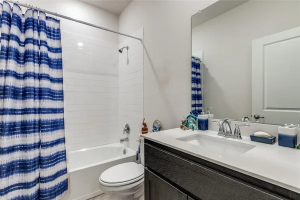 a bathroom with a granite countertop sink toilet mirror and shower
