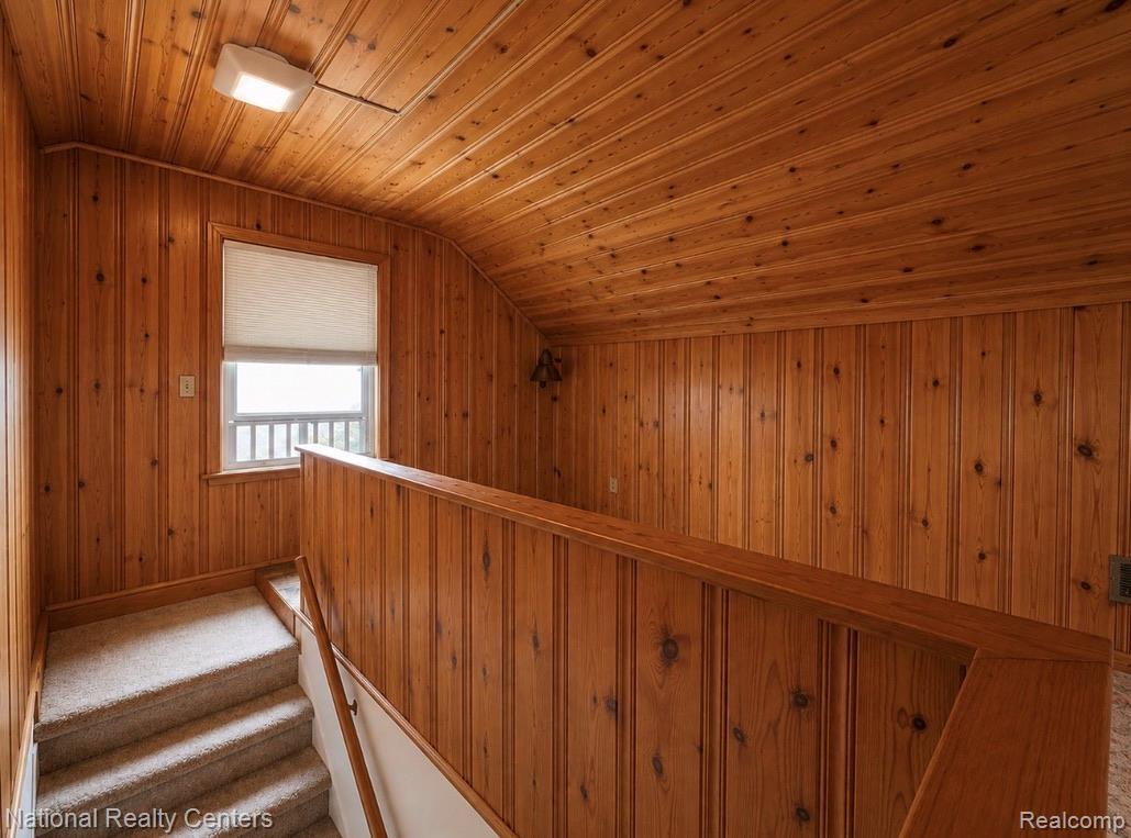 7285 Helen Street Center Line, MI 48015 - Photo 19 of 32 Wood-paneled upper landing featuring a window with privacy blind, textured carpeted stairs, and a wood railing