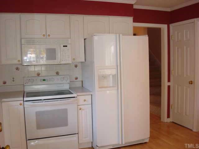 3605 Old Country Lane Raleigh, NC 27616 - Photo 4 of 10 Lovely kitchen w/tile backsplash and top of the line appliances including a built in microwave and smooth top self cleaning oven. Side by side refrigerator conveys. Laminate flooring and french door to porch w/built-in blinds.