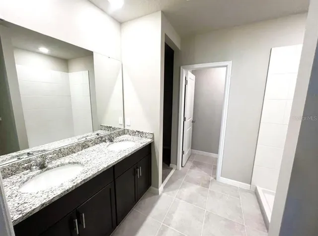 a bathroom with a granite countertop sink and a mirror