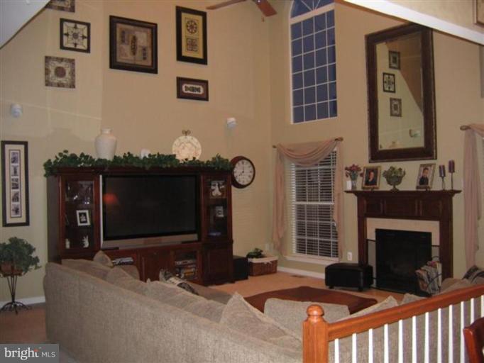 14504 Bubbling Spring Road Boyds, MD 20841 - Photo 7 of 21 a living room with furniture a flat screen tv and a fireplace