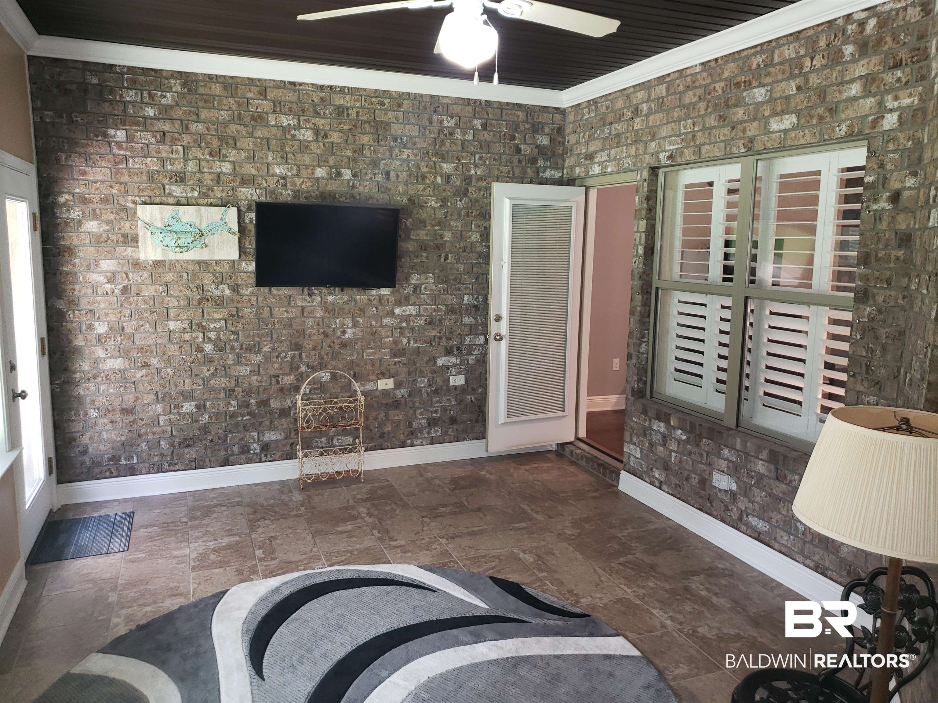 23373 Dundee Circle Foley, AL 36535 - Photo 11 of 34 Tiled living room with brick wall, crown molding, and ceiling fan