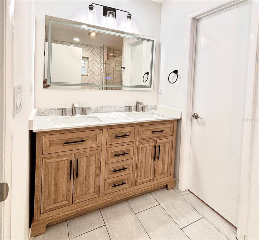 2140 Pinehurst Street Sarasota, FL 34231 - Photo 36 of 40 a bathroom with a granite countertop sink a mirror and a