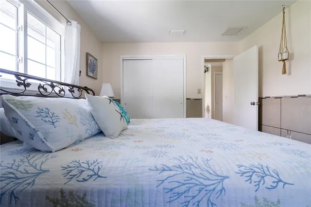 a bedroom with a large bed and wooden floor